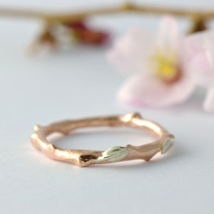 Puede incluir: Un anillo de rama de oro rosa con delicadas hojas de oro blanco. El anillo es un dise&ntilde;o &uacute;nico e inspirado en la naturaleza.