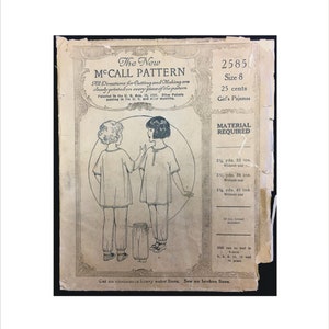 Peut inclure: Un patron de couture vintage McCall's pour un pyjama de fille. Le patron est pour la taille 8 et coûte 25 cents. Le patron comprend des instructions pour couper et confectionner le pyjama. Le patron est imprimé sur du papier crème avec de l'encre noire. Le patron comprend un dessin de deux filles portant le pyjama.
