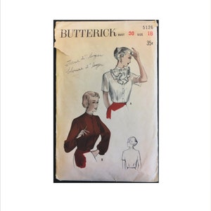 May include: Vintage sewing pattern for a blouse with a ruffled collar. The pattern is from Butterick, size 18, bust 36, and costs 35 pence. The pattern shows three different views of the blouse.