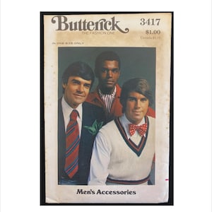 Peut inclure: Une pochette de patron de couture vintage Butterick 3417 pour accessoires. La couverture présente trois personnes portant un costume sombre avec une cravate rayée, une veste rouge avec une chemise rayée et un pull sans manches blanc avec un nœud papillon rouge à pois.