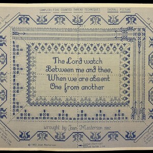 May include: A blue and white counted thread sampler with the text "The Lord watch Between me and thee, When we are absent One from another." The sampler includes decorative borders and the text "wrought by Joan Masterson 1982."