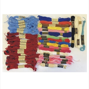 May include: A collection of colorful embroidery floss in various shades of blue, red, pink, yellow, green, and white. Each skein is labeled with a brand name and number. Ideal for cross-stitch, embroidery, and other needlecraft projects.