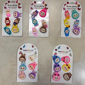 May include: Several sets of shoe charms in various colors, including pink, blue, yellow, and brown. Each set features cartoon bunny designs with the text "Fashion Jewelry SHOE CHARMS DECOR YOUR SELF".