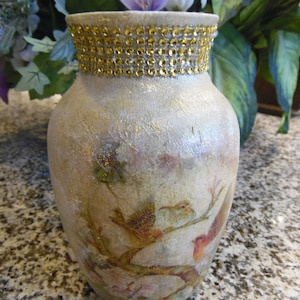 Birds are decoupaged on vase, hand painted vase and gold trim around the top