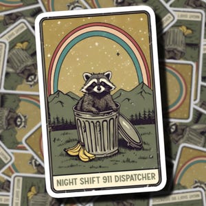 May include: A rectangular sticker featuring a raccoon sitting inside a metal trash can. The background shows mountains, a forest, and a rainbow under a starry sky. A bunch of bananas sits near the can. The text reads NIGHT SHIFT 911 DISPATCHER.