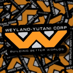 May include: A sticker displaying the Weyland-Yutani Corp logo, an orange "W" design with white details, overlaid on a background of the company logo and text. The words "BUILDING BETTER WORLDS" are beneath the logo.