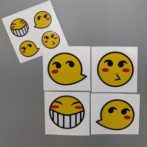 May include: Six yellow stickers with cartoon faces. Each sticker has a different expression, including smiling, winking, and frowning. The stickers are printed on white paper.