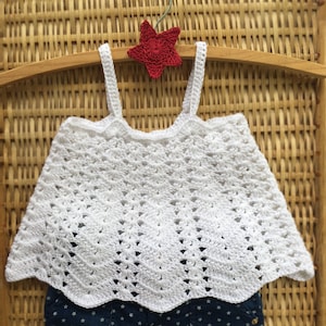 May include: White crochet tank top with a scalloped hem, paired with blue denim shorts with white stars.