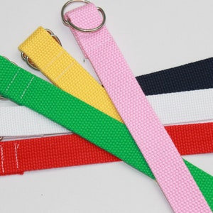 May include: Five different colored webbing straps with metal D-rings. The straps are red, white, navy blue, yellow, and pink.