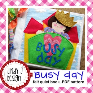 May include: A handmade felt quiet book with a colorful design. The cover features a house with a princess wearing a gold crown. The book has the words "Busy Day" and the name "Keira's" on the cover. The book is made by Lindy J Design.