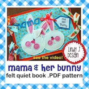 Può includere: Un libro tranquillo in feltro con sfondo blu e design a coniglietto. Il libro presenta le parole "mama" e "and her bunny". I coniglietti hanno accenti rosa e sono circondati da un motivo a carote.