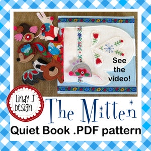 May include: A handmade quiet book with a mitten design, featuring felt animal characters. The book is white and blue, with floral and snowflake accents. The text "The Mitten" and "Quiet Book .PDF pattern" are displayed.