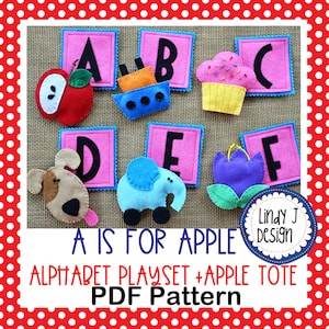 Może przedstawiać: Filcowy zestaw do zabawy z alfabetem z jabłkiem, łodzią, babeczką, psem, słoniem i kwiatem. Każda litera znajduje się na różowym kwadracie z niebieską obwódką. Widoczny jest również tekst "A IS FOR APPLE" i "ALPHABET PLAYSET + APPLE TOTE PDF Pattern".