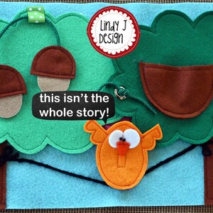 Puede incluir: Un juego de fieltro con un &aacute;rbol verde, bellotas marrones, una casita de p&aacute;jaros marr&oacute;n y un p&aacute;jaro naranja con un pico rojo. El texto "this isn't the whole story!" est&aacute; escrito en una pancarta blanca.