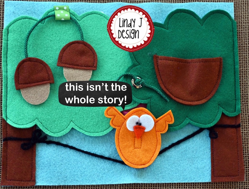 Puede incluir: Un juego de fieltro con un &aacute;rbol verde, bellotas marrones, una casita de p&aacute;jaros marr&oacute;n y un p&aacute;jaro naranja con un pico rojo. El texto "this isn't the whole story!" est&aacute; escrito en una pancarta blanca.