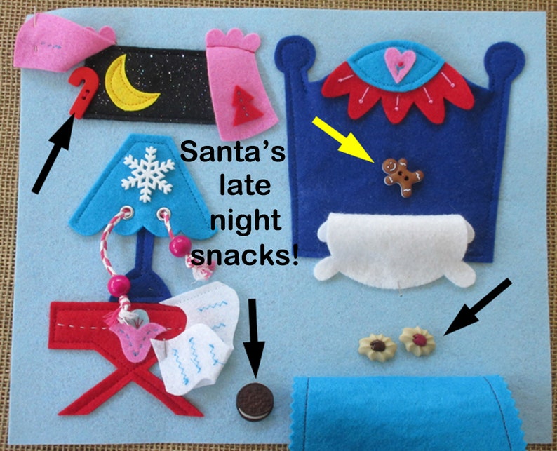 Op de afbeelding: Een vilt speelset dat Santa's late-night snacks afbeeldt. De set bevat een bed, een tafel, een lamp en verschillende etenswaren zoals koekjes, een peperkoekman en een Oreo-koekje. De tekst "Santa's late night snacks!" staat op het vilt.