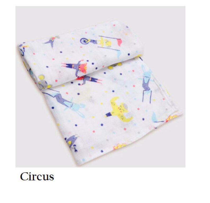 May include: White muslin baby swaddle with a colorful circus theme print. The print features a variety of circus performers, including a strongman, a clown, and a unicyclist. The swaddle is decorated with small white polka dots.