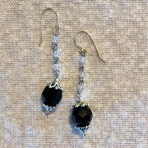May include: A pair of dangle earrings with black faceted beads and clear crystal beads on a silver chain.