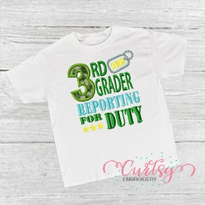 May include: White t-shirt with green, blue, and yellow embroidery that reads "3rd Grader Reporting for Duty".