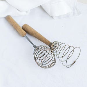 Vintage whisk, metal hand-whisk, retro kitchenware, spiral barrel cone, wooden handle, rustic home decor, old rusty cooking tool, egg beater