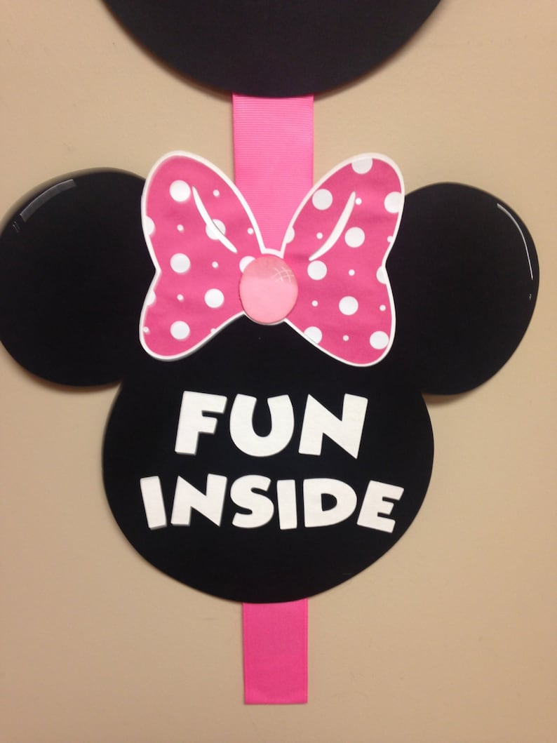 May include: Black and white Minnie Mouse ears with a pink bow and white polka dots. The ears have the text "FUN INSIDE" written in white.