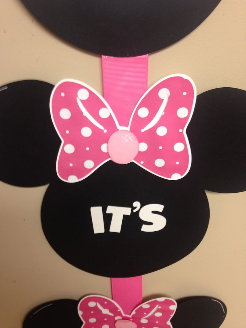 May include: Black and pink Minnie Mouse themed party decoration with the text "IT'S" in white letters.