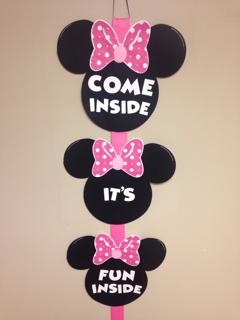 May include: Three black and white Minnie Mouse head cutouts with pink bows and white polka dots. The top cutout says "Come Inside", the middle cutout says "It's", and the bottom cutout says "Fun Inside".