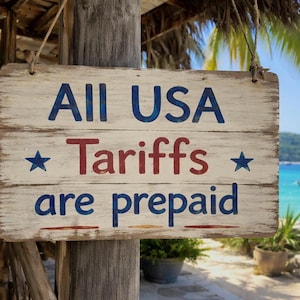 May include: Weathered wooden sign with the text "All USA Tariffs are prepaid" in blue and red lettering. The sign is hanging outdoors with a tropical beach scene in the background.