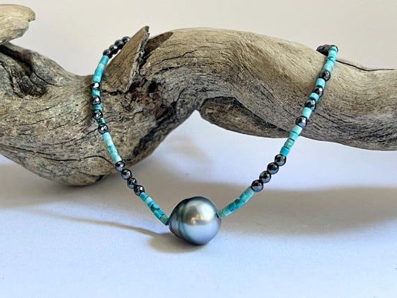 A delicate bracelet featuring a beautiful dark grey Tahitian pearl surrounded by turquoises and hematites tiny beads.