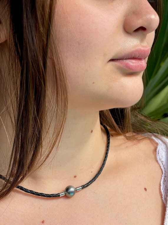 Necklace made with a beautiful semi-round Tahitian pearl on round braided black leather. Steel Clasp, unisex necklace 45,5cm length