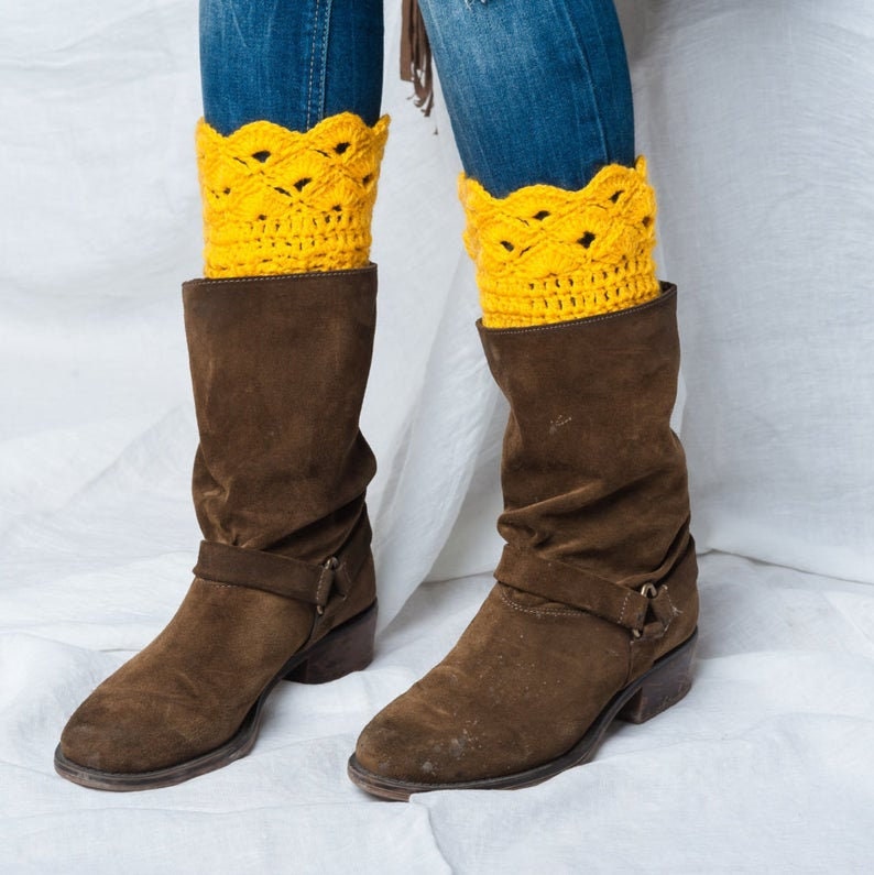 May include: Brown suede boots with a buckle strap and yellow crocheted leg warmers.