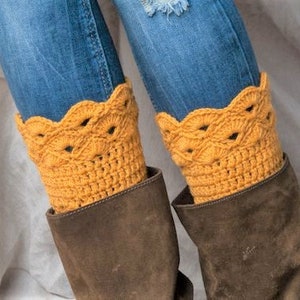 May include: A pair of brown suede boots with yellow crocheted leg warmers. The leg warmers have a scalloped edge and a delicate openwork design.