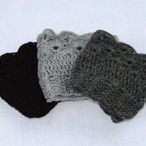 May include: Three crocheted hats in black, grey, and light grey. The hats are made with a textured stitch and have a scalloped edge.