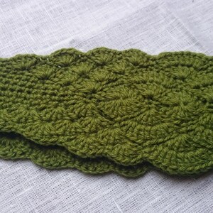 Peut inclure: Un chauffe-cou crochet&eacute; vert avec deux boutons noirs.
