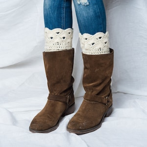 Peut inclure: Bottines en daim marron avec une boucle et des jambières en crochet blanc.