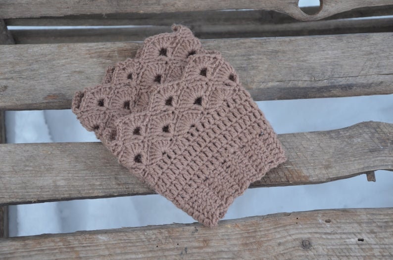 May include: A brown crocheted leg warmer with a lacy pattern.