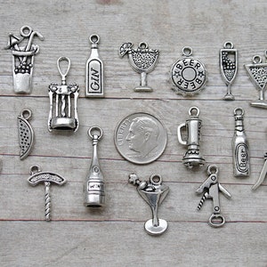 May include: A collection of 17 silver-toned metal charms featuring various drink and beverage themes, including wine, beer, gin, and cocktails. The charms are perfect for adding a touch of personality to jewelry, keychains, or other crafts.