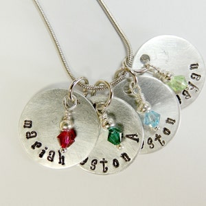 Puede incluir: Collar de plata con cuatro colgantes redondos de plata, cada uno con un nombre grabado: Mariah, Justin, Ashton y Ryan. Cada colgante tiene una pequeña cuenta de cristal: roja, verde, azul y verde claro.