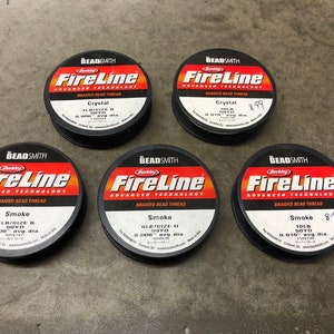 以下が含まれることがあります： バークレーファイヤーラインの編組ビーズスレッドが5個。スプールは黒で、赤と白の文字が書かれています。スプールには、クリスタル、スモーク、4LB/サイズBなど、さまざまなサイズと色の糸がラベル付けされています。1個のスプールの価格は8.99ユーロです。
