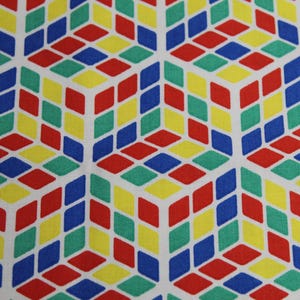 May include: A repeating pattern of colourful geometric shapes. The pattern is made up of red, blue, green, and yellow squares and diamonds. The background is white.