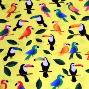 May include: A yellow fabric with a repeating pattern of colourful toucans and parrots. The birds are depicted in a stylised, cartoon-like manner.