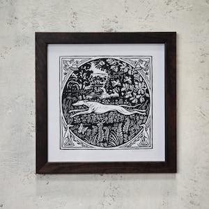 May include: Black and white woodblock print of a dog running through a forest scene. The print is framed in a dark wood frame.