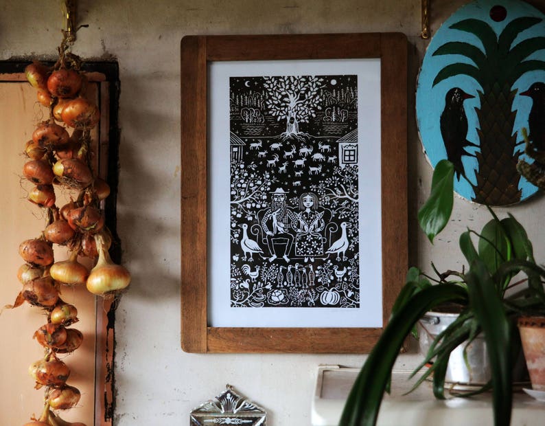 May include: A black and white illustration of a couple sitting on a bench under a tree. The illustration is framed in a wooden frame and hanging on a wall.