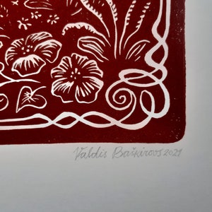 May include: A red print with white floral designs and a white border. The print is signed "Valdis Bā&scaron;kirovs 2021" in the bottom right corner.