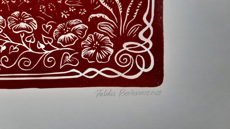 May include: A red print with white floral designs and a white border. The print is signed "Valdis Bā&scaron;kirovs 2021" in the bottom right corner.