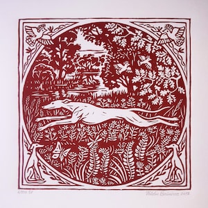May include: A red and white woodblock print of a running dog in a forest setting. The print is framed in a square border with a floral design. The text "Valdis Basanovs 2017" is in the lower right corner.
