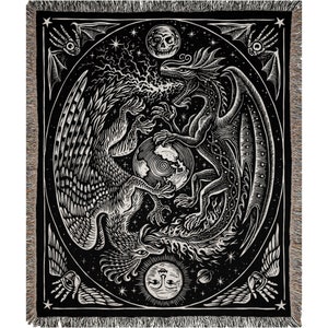 May include: Black and white woven tapestry featuring a stylized image of a dragon and a griffin facing each other. The creatures are surrounded by stars and celestial bodies, including a crescent moon and a sun. The tapestry has a black background and a woven border.