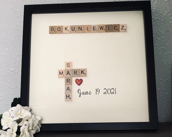 Könnte beinhalten: Ein gerahmtes Kunstwerk mit einem roten Herzen und Scrabble-Steinen, die das Wort "MARK" und das Datum "June 19 2021" buchstabieren.