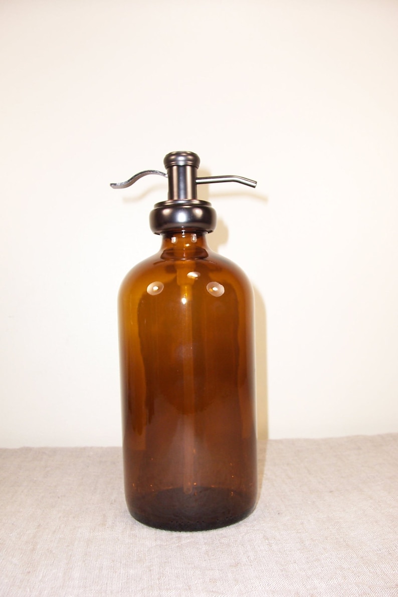 May include: A brown glass bottle with a metal pump dispenser. The bottle is empty and ready to be filled with soap or lotion.