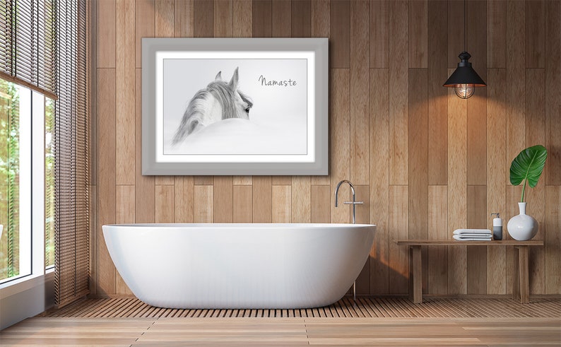 Pu&ograve; includere: Una fotografia in bianco e nero di una testa e un collo di cavallo, con la parola "Namaste" stampata sotto. La foto &egrave; incorniciata in una cornice grigia e appesa a un muro di legno sopra una vasca da bagno bianca.